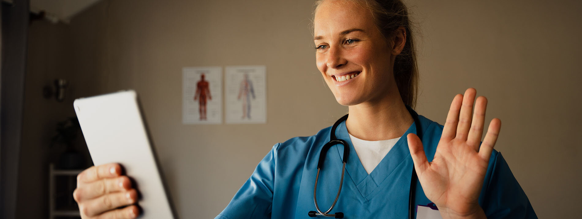 Beautiful young caucasian female doctor on video call from practice at home, smiling and waving at patient Feedtrail - Healthcare Experience Management